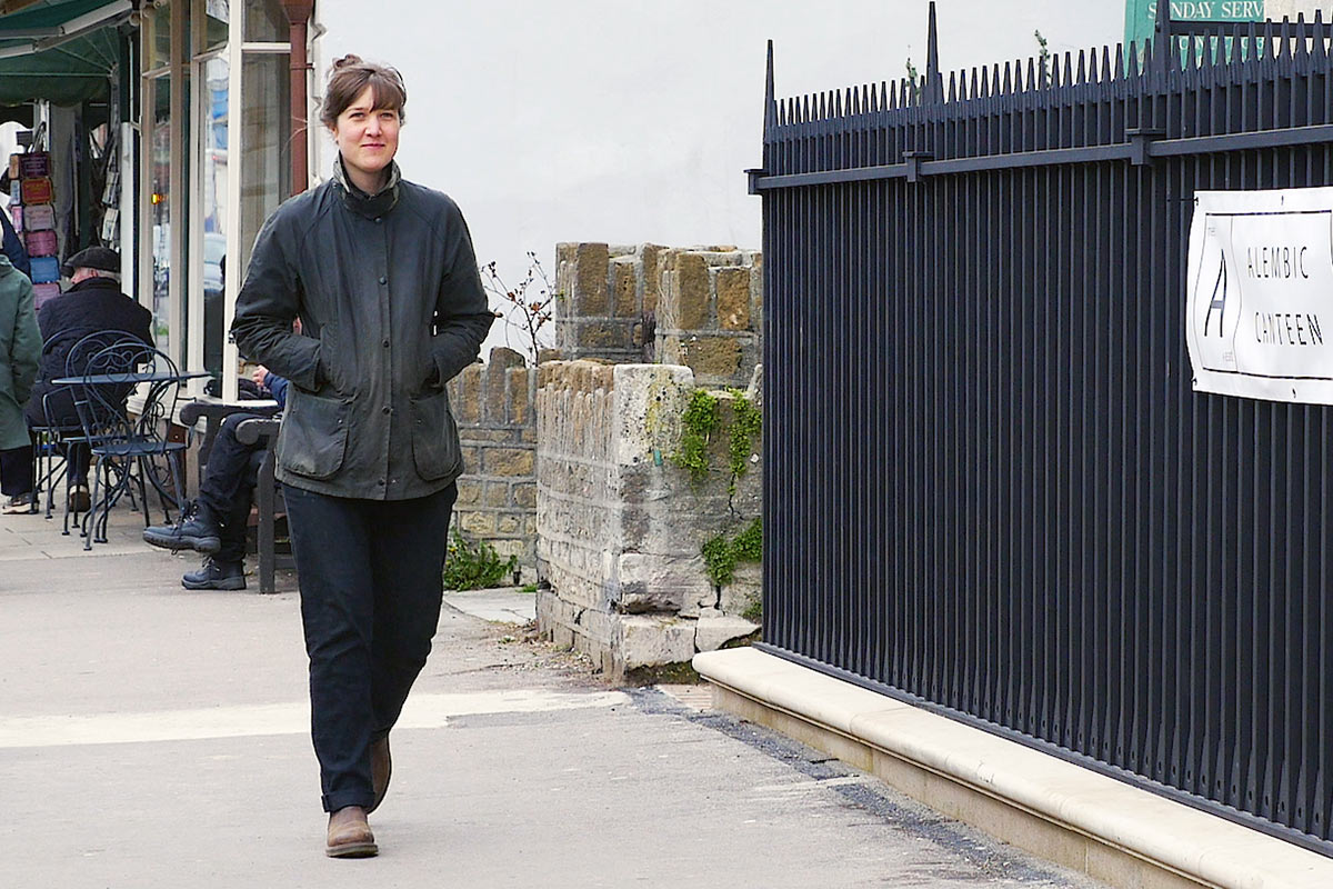 Alice Blogg walking past some railings in Bridport