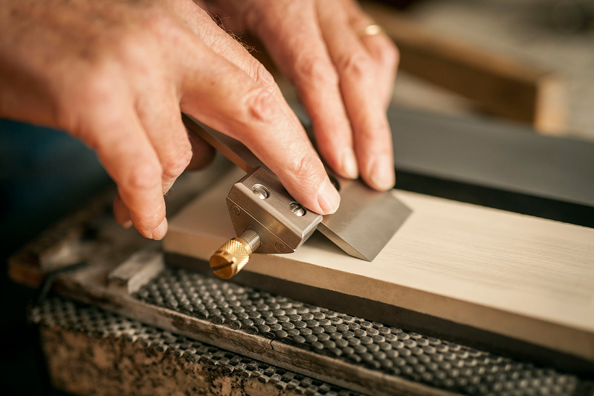 Plane blade in a honing guide ready to sharpen on a waterstone