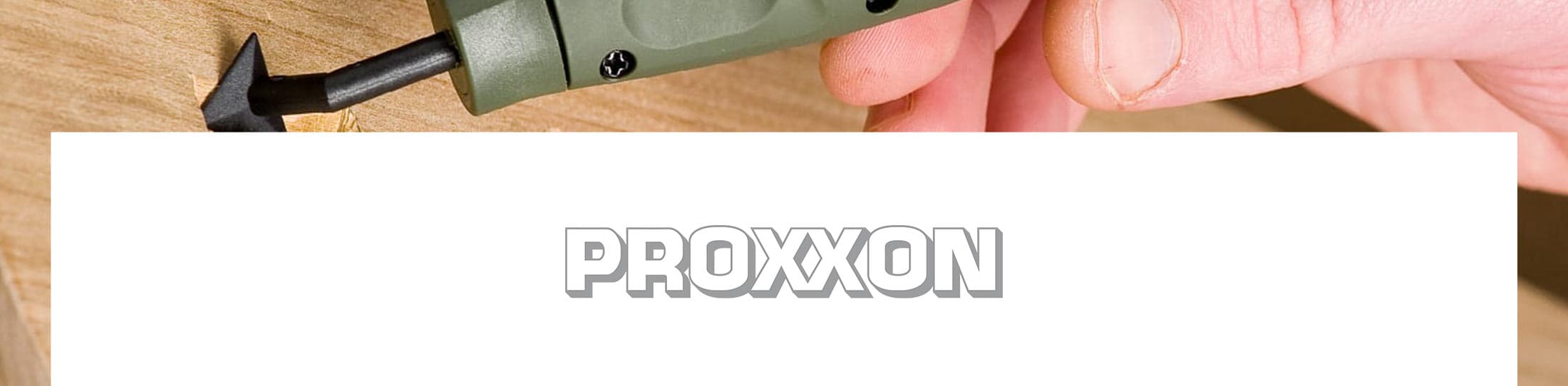 A close-up of a hand holding a green and black Proxxon tool against a light wood background, with a large white banner across the lower half displaying the brand name 'PROXXON'.