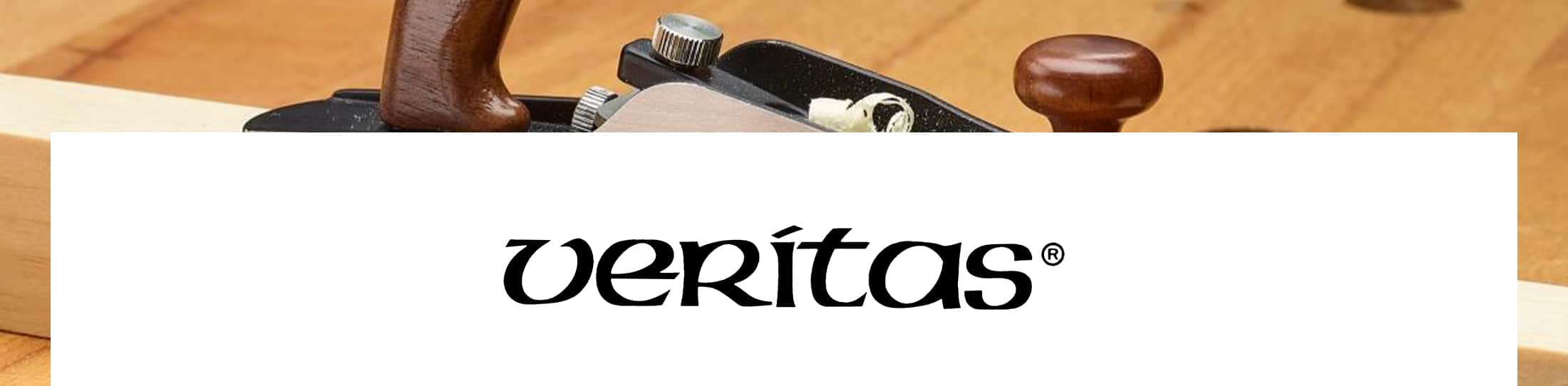 A close-up of a woodworking hand plane on a light wood surface, with a large white banner across the lower center displaying the veritas brand name in black script.