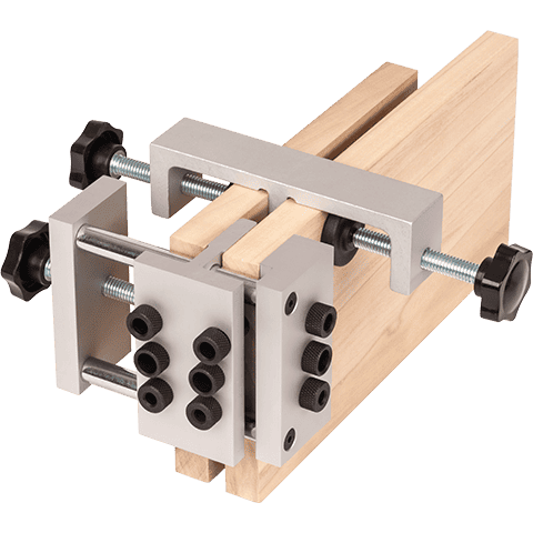 A metal jig or clamp fixture with silver aluminum blocks, black adjustment knobs, and wooden guide rails, shown on a plain white background.