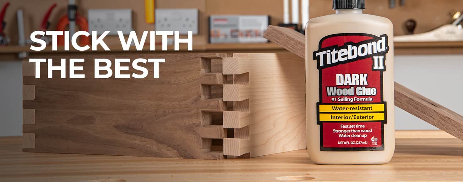 A bottle of Titebond II Dark Wood Glue stands on a wooden workbench next to a wooden interlocking joint, with the text 'STICK WITH THE BEST' overlaid on the left side.