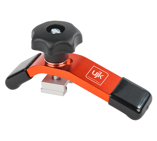 An orange and black UJK aluminum clamp tool with a black star-shaped adjustment knob, black handles, and a silver metal base, shown on a solid white background.